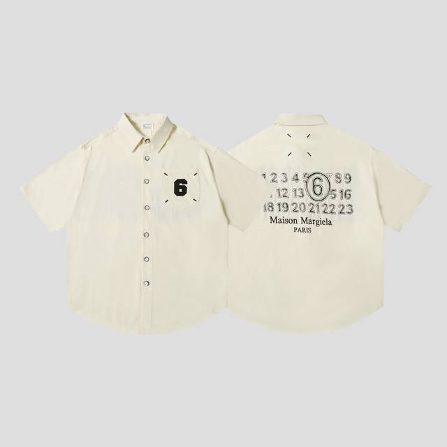 上新 Maison Margiela 马吉拉设计师款24Ss剪花数字贴布半袖衬衫 工艺：剪花数字贴布 定制纽扣 颜色：黑色 杏色 尺码：S-Xl 简介： 马丁